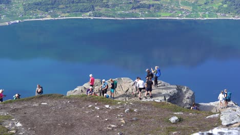 Crowd-of-people-are-taking-pictures-and-using-social-media-at-Dronningstien-queens-hiking-trail-between-Lofthus-and-Kinsarvik-in-Norway---Hardangerfjord-background---Static-handheld