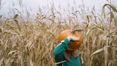 Young-Girl-Wth-Pumpkin-Head-Dancing-In-The-Cornfields