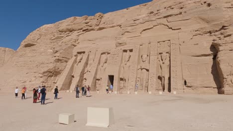 Panning-shot-of-tourists-admiring-the-stunning-Abu-Simbel,-Egypt