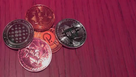 Bitcoin--Und-Polkadot-münzen-In-Roter-Farbe,-Die-Den-Volatilen-Bärenmarkt-Auf-Blockchain-Web-3-Darstellen,-Digitale-Zahlungen,-Lichtreflexionen,-Makroaufnahme-Im-Vordergrund,-Die-Von-Oben-Rollen,-Galizien,-Spanien