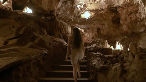 Following-and-rotating-around-young-woman-exploring-the-cave-of-Saint-Cezaire