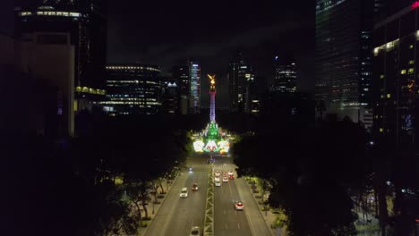 Aerial-view-of-the-Reforma-avenue-and-the-Angel-of-Independence,-illuminated-in-Mexican-flag-colors-on-national-night-in-Mexico-city