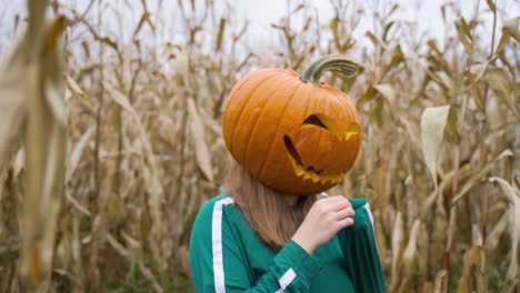 Young-Woman-With-Carved-Pumpkin-Head-Wearing-Green-Tracksuit