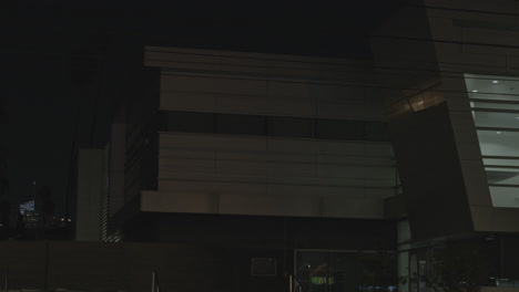 Static-shot-of-a-local-Police-Station-office-building-at-night-with-some-traffic-movement-in-the-foreground