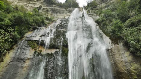 New-Zealand-Tall-Cliff-Waterfall-in-Hawkes-Bay,-Low-Angle-Waterfall-Looking-Up