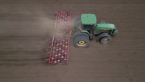 Trockenes-Landwirtschaftliches-Feld-Wird-Für-Die-Aussaat-Mit-Traktor-Und-Egge-Vorbereitet