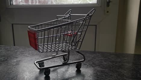 Mini-empty-shopping-cart-online-home-supermarket-concept-copy-space-closeup-orbit-right
