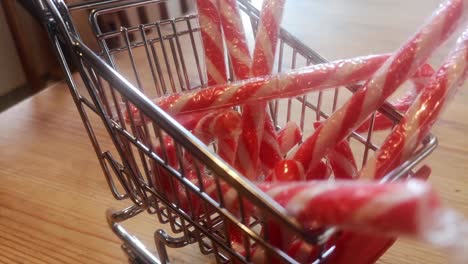 Small-shopping-trolley-filled-with-Christmas-candy-canes-home-delivery-concept-kitchen-idea-rotate-left-slow