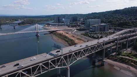 Forward-drone-shot-of-Downtown-Portland-Oregon-Waterfront-Bridges-with-cars-passing-by