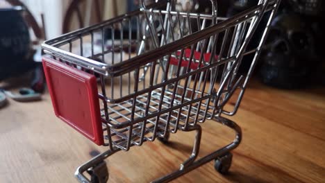 Small-shopping-trolley-online-home-business-concept-on-kitchen-table-copy-space-closeup-pull-away-left