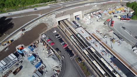 VY-train-in-Arna-driving-into-tunnel-and-heading-for-city-of-Bergen---Aerial-from-Arna-station-Norway