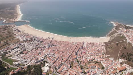Wide-aerial-drone-view-of-Nazare-gulf-and-cityscape,-Portugal