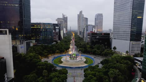 Aerial-view-away-from-the-El-angel-de-la-Independencia-on-Reforma-Avenue,-in-gloomy-Mexico-city---pull-back,-drone-shot