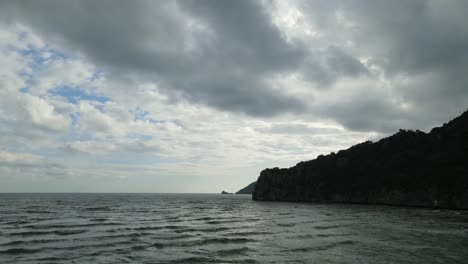 Luftaufnahmen,-Die-Nach-Links-Gleiten,-Zeigen-Einen-Kalksteinberg,-Dann-Erscheinen-Inseln-Am-Horizont,-Graue-Wolken-Und-Blauer-Himmel