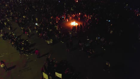 Aerial-view-of-a-riot,-people-burning-stuff-on-the-streets-of-Mexico-city,-during-nighttime