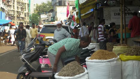 Statische-Aufnahme-Eines-Mannes,-Der-Seinen-Ladenbereich-Putzt,-Und-Menschen,-Die-Trockenfisch-Vom-ältesten-Und-Größten-Großhandelsmarkt-Für-Trockenfisch-In-Wadala,-Mumbai,-Kaufen