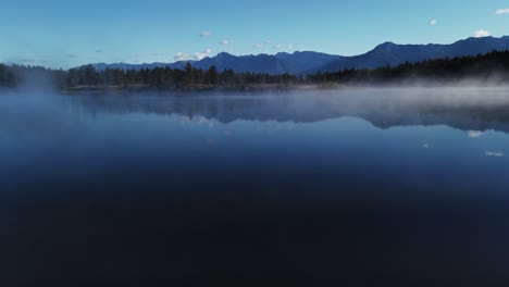 Lake-with-mist-by-forest-at-mountains-Enid-British-Columbia-Canada