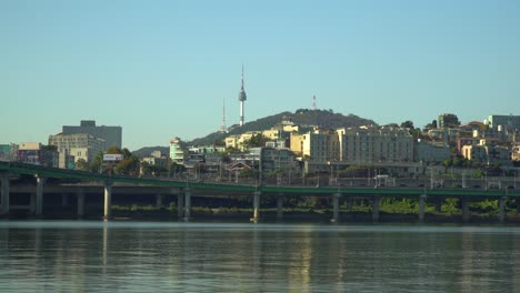 Zoom-in-to-N-Seoul-Tower-or-Namsan-Tower-from-Han-river-riverbank-on-cloudless-autumn-day,-Yongsan--ru,-Seoul-South-Korea-realtime-4k