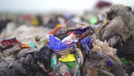 Non-recyclable-waste-dumped-in-a-landfill.-Close-up,-handheld