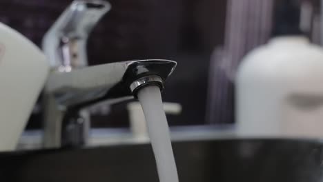 Water-running-from-a-faucet-into-a-sink