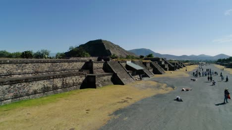 Aerial-view-over-tourists-and-towards-the-Temple-of-the-sun,-in-sunny-Teotihuacan,-Mexico---rising,-drone-shot