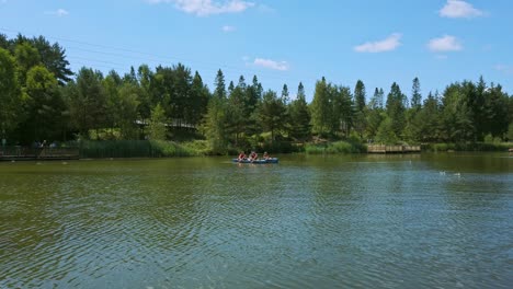 Family-kayak-on-lake-in-forest-as-zip-liners-descend-in-background