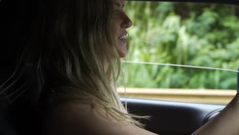 Mujer-Atractiva-Conduciendo-Por-Una-Carretera-Rural-Sonriendo