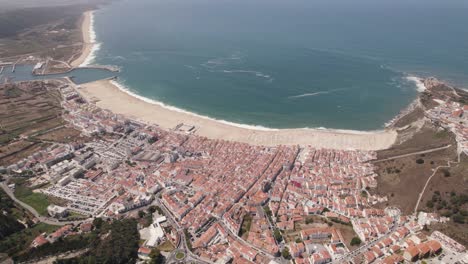 Aerial-high-view-Nazaré-Cityscape-and-beach-waterfront,-Coastline-Holiday-Village