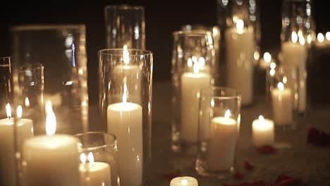 Rows-of-candles-burning-in-dark-space