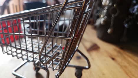 Small-shopping-trolley-online-home-business-concept-on-kitchen-table-copy-space-closeup-orbit-left