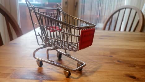 Mini-empty-shopping-trolley-online-home-delivery-concept-on-kitchen-table-pull-back