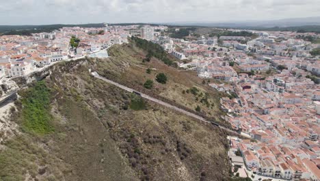 Aerial-Orbit-over-Nazaré-Railway-Funicular-on-hillside-scenic-overlook-of-Sitío-Nazar?