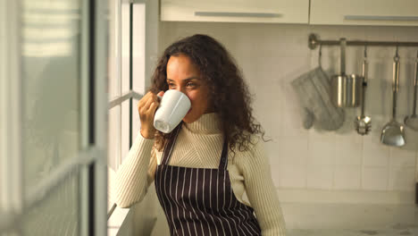 beautiful-Latin-woman-drinking-coffee-in-kitchen
