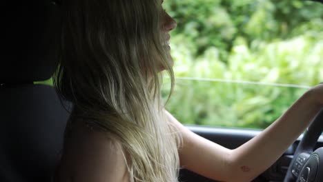 Slow-motion-attractive-woman-driving-and-smiling-with-the-window-down