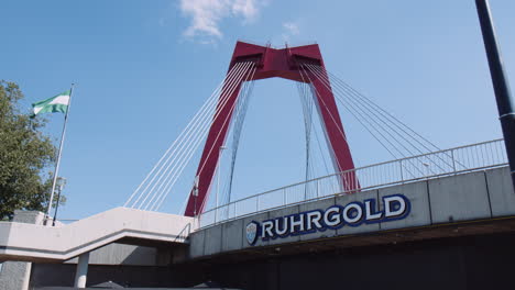 Slowmotion-tilting-shot-of-the-Willemsbrug-Bridge-from-below-with-a-flag-flying