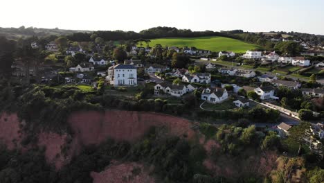 Schwenken-Der-Rechten-Aufnahme-Von-Häusern-Am-Rand-Der-Klippe-Bei-Seaton-Hole-In-Devon,-Großbritannien