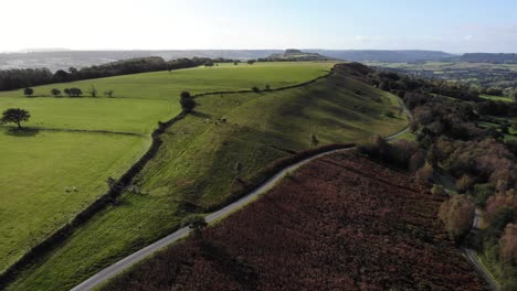 Rückwärtige-Luftaufnahme,-Die-Den-Wunderschönen-Hartridge-Hill-In-East-Devon-Mit-Der-Englischen-Landschaft-Dahinter-Zeigt