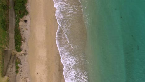 Gentle-waves-crashing-onto-pristine-Amami-beach,-Japan---aerial-top-down