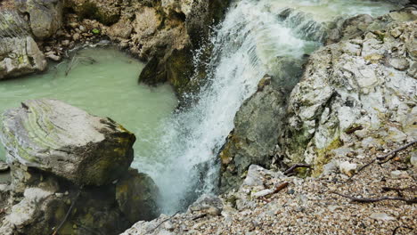 Aufnahme-Von-Oben-Nach-Unten-Eines-Wasserfalls,-Der-In-Ein-Vulkanisches-Becken-Im-Geothermischen-Gebiet-Wai-o-tapu,-Nz,-Fließt