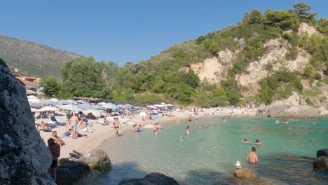 Playa-Concurrida-Con-Muchos-Turistas-Europeos-Disfrutando-De-Sus-Vacaciones-En-La-Playa-En-Parga,-Grecia