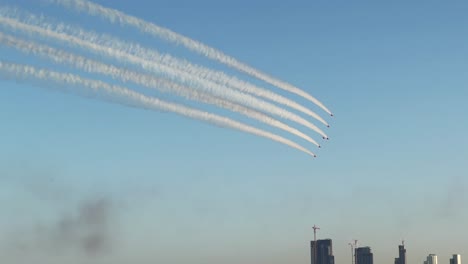 Close-up-of-the-Red-Arrows-aerobatic-team-with-Kuwait-City-skyline-in-the-Background