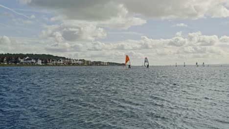 Windsurfers-at-coastal-West-Kirby-marine-lake-enjoying-water-sports-activity-on-a-perfect-day