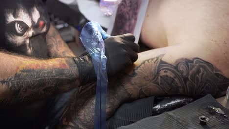 Tätowierer,-Der-Das-Tattoo-Auf-Dem-Arm-Seines-Kunden-Ausmalt