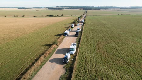 Aerial-view-over-vehicles-parked-Stonehenge-rural-road-towards-ancient-stone-circle-landmark