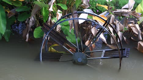4k-Kleines-Wasserrad,-Das-Sich-In-Trübem-Wasser-Dreht
