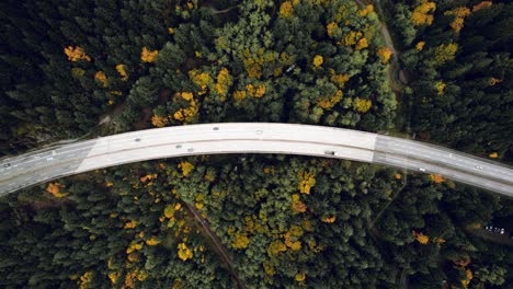 Top-Down-Cinematic-Shot-of-Epic-Mountain-Highway-through-Forest,-Curved-Road-with-Cars-and-Trucks-in-Fall,-West-Vancouver-Canada