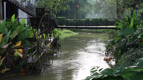 4k-Wasserrad-Dreht-Sich-Langsam-Mit-Holzpaddeln-Und-Metallrahmen-In-Einem-Fließenden-Fluss