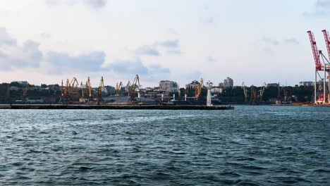 Industrial-Harbour-Jib-Cranes-At-Port-Of-Odesa-From-A-Boat-Sailing-Cruising-At-Black-Sea
