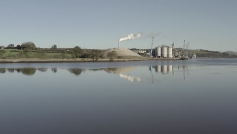Riverside-cement-plant-in-Ireland-with-tall-smoke-stack-seen-beyond