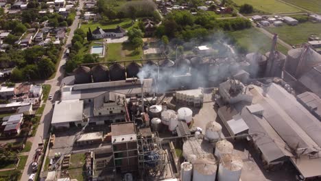 Drone-flying-over-industrial-chimney-of-food-factory-in-Buenos-Aires-province,-Argentine